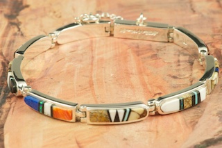 Genuine Picture Jasper, Spiny Oyster Shell, Blue Lapis and Black Jade inlaid between ribbons of Sterling Silver. Stunning Bracelet features precision channel inlay. Designed by Navajo Artist Calvin Begay. Signed.
